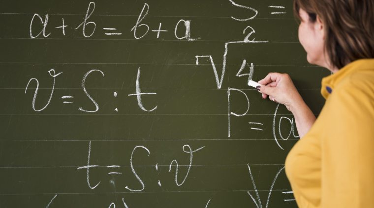 low-angle-teacher-writing-chalkboard